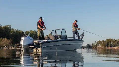 Deux hommes pêchant sur un bateau dans un lac. 