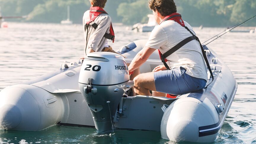 Homme sur un bateau équipé d’un moteur BF15 en zone côtière. 