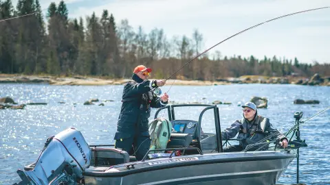 Hommes pêchant depuis un bateau équipé d’un moteur Honda BF30 sur un lac.