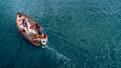 Couple sur un bateau équipé d'un moteur Honda sur l'eau.