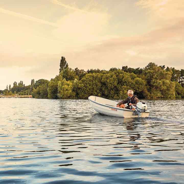 Personne sur un bateau avec un moteur Honda, sur un lac. 