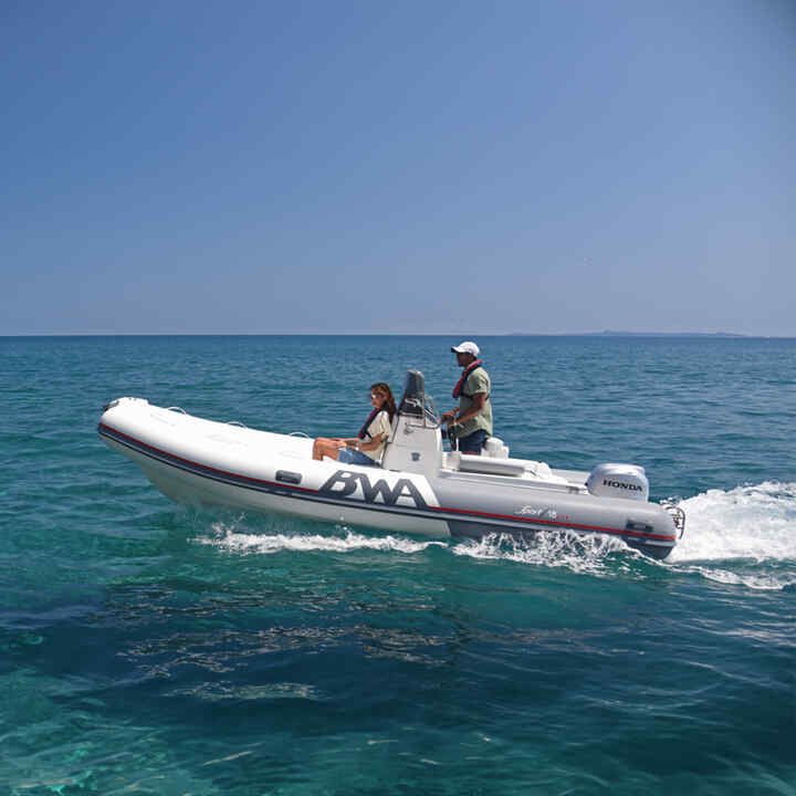 Couple sur un bateau de profil équipé d'un moteur Honda BF, en mer.