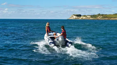 Mannequin conduisant un bateau à moteur BF80-10 en mer.