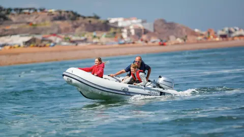 Famille sur un bateau en mer utilisant un moteur BF8-10.