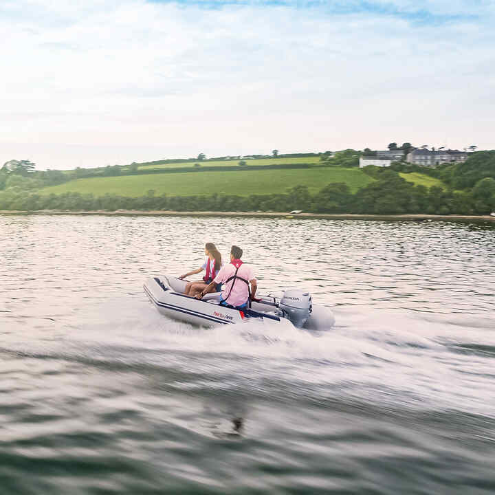 Couple sur un bateau Honwave au bord d'un lac utilisant un moteur Honda BF. 