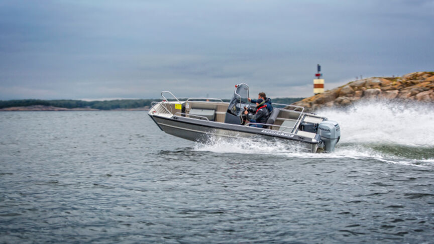 Mannequin pilotant un bateau en mer, équipé du moteur BF80-100.