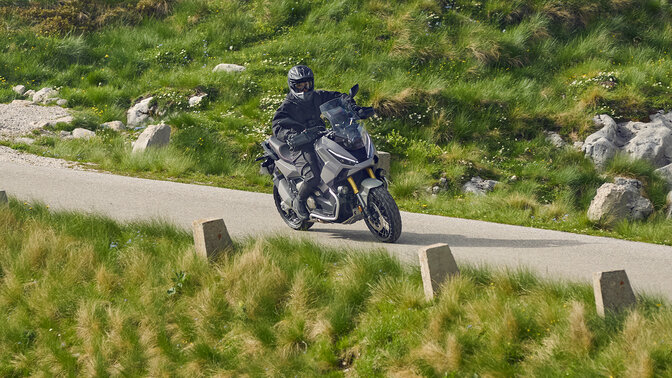 Pilote sur Honda X-ADV dans un endroit montagneux.