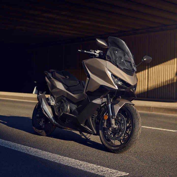 Scooter Forza 750 garé sur la route.